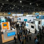A bustling CES show floor with attendees exploring various smart home booths and interactive displays.
