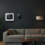 A smart thermostat on a wall in a modern living room.