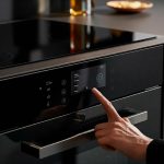 A smart oven with a touchscreen control panel and a connected cooktop that can be controlled remotely.